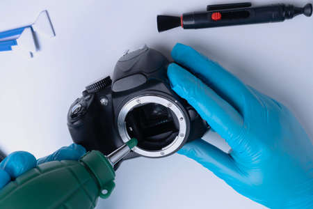 Master cleans the DSLR camera sensor with a blower. selective focusの写真素材