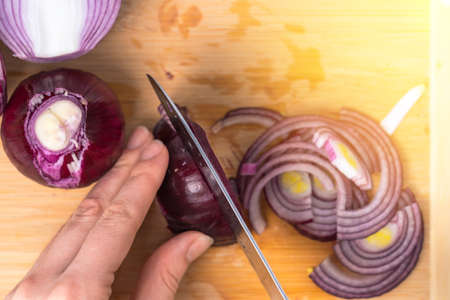 Cook cuts purple onion, top view