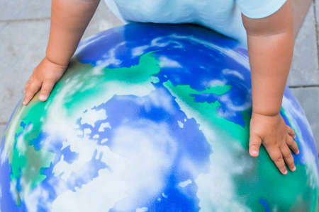 children's hands embrace the layout of the planet earthの写真素材