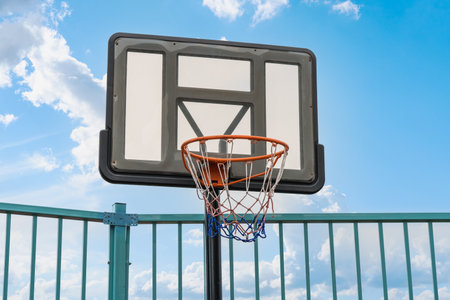 Basketball hoop on the playground against the sky with cloudsの写真素材