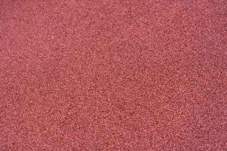The texture of red rubber crumbs at a sports stadiumの写真素材