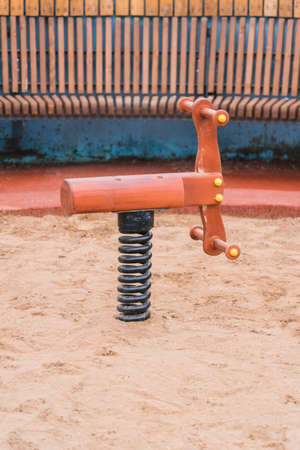 Children's toy rocking chair in the form of a wooden horse on the playgroundの写真素材