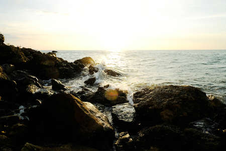 The waves that hit the shore with the light sunの写真素材