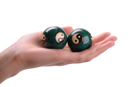 Green Chinese balls for relaxation on woman hand on white backgroundの写真素材