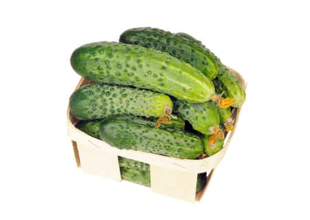 pile of cucumber in a veneer basket isolated over white backgroundの写真素材