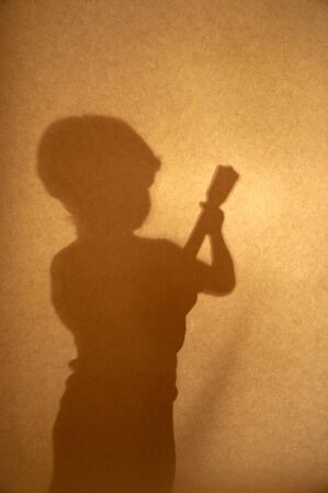 sepia silhouette of a boy playing guitar