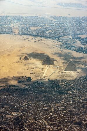 The Giza pyramid complex, also called the Giza Necropolis viewed from airplane window. Khufu,...