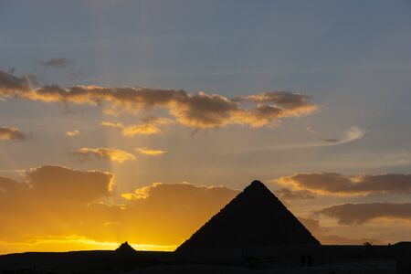 Sunset in Giza pyramid complex. The Sun is going down behind the Pyramid of Menkaure.