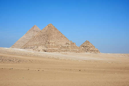 View on Khafre, Menkaure and pyramids of Queens from desert. Several horse and camel riders in the...
