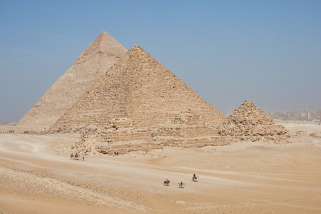 View on Khafre, Menkaure and pyramids of Queens from desert. Several horse and camel riders in the frame.のeditorial素材