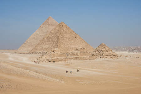 View on Khafre, Menkaure and pyramids of Queens from desert. Several horse and camel riders in the frame.のeditorial素材
