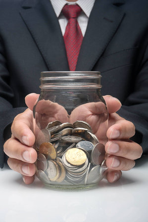 Saving concept  A hand Holding jar of money の写真素材