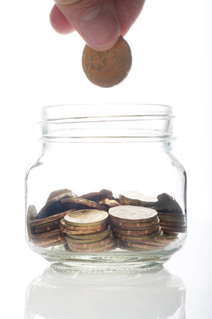 Hand putting a coin into glass bottle