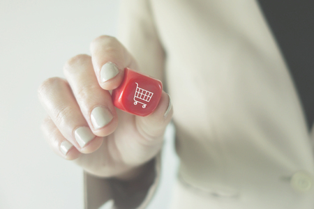 Shopping concept: Business woman holding a dice with Trolley iconの写真素材