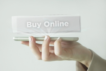 Close-up Of young businesswoman's hand holding smartphone with Buy Online wordの写真素材