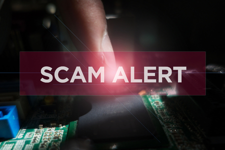 Cyber Security Concept: Close-up of electronic circuit board with Scam Alertの写真素材