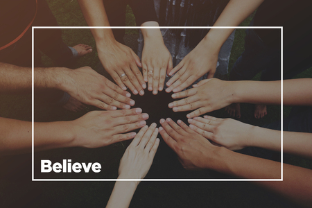 Hands together with text: Believeの写真素材