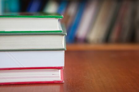 Copyspace of stack books over bookshelf backgroundの写真素材