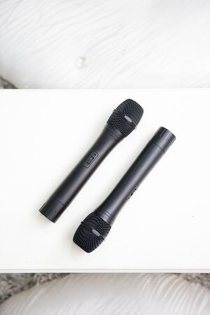 a pair of black microphone on a white tableの写真素材