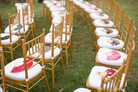 Batik motives wooden hand fans are put on chiavary chair for guest on a wedding dayの写真素材