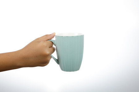 a man hand holding a blue coffee cup isolate on white backgroundの写真素材