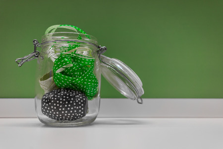 A shot of colorful ribbons in a glass container shot against a green background.の写真素材