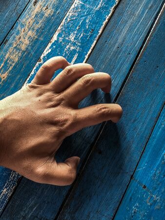 A shot of a human hand scratching a table top.の写真素材