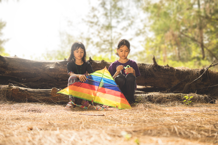 kampung Mek Mas, Kota Bahru, Kelantan / Malaysia - July 15, 2017 : A shot of two young girls with sad faces trying to figure out how to fly the kite.のeditorial素材