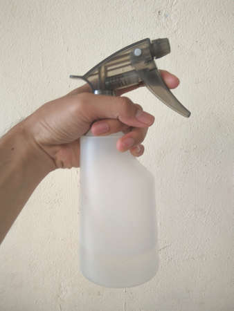 hand holding a white spray bottleの写真素材