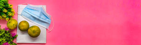 object with flowers decoration on soft pink background. with the theme of back to school during a pandemic. perfect for cover and banner concepts. copy space, flat lay, top view.の写真素材