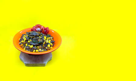 a bowl of delicious black pepper beef on a yellow background, copy space food background, studio...