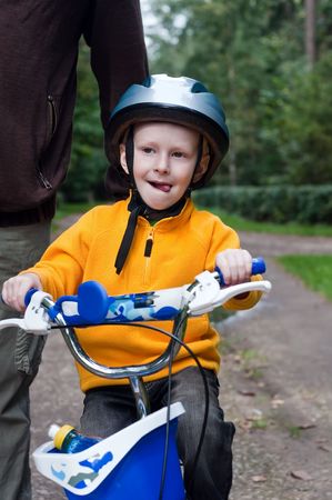 Father helping his son learning to ride a bike.の写真素材