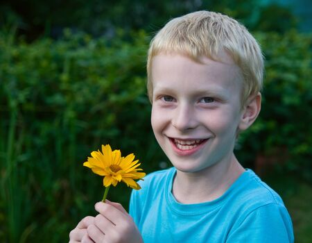 cute blond boy with a flowerの写真素材