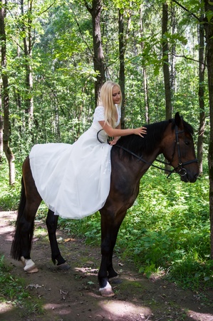 Beautiful bride on horseback in the forestの写真素材