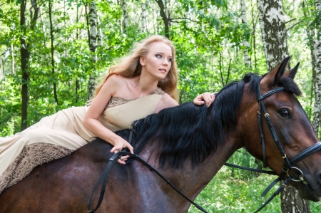 Young pretty girl on horseback in the forestの写真素材