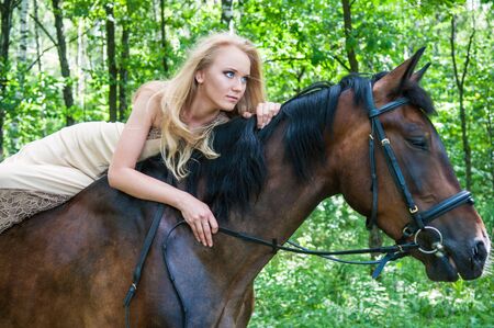 Beautiful bride on horseback in the forestの写真素材