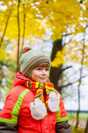 Happy child in autumn parkの写真素材