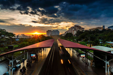 Dramatic sunrise at KTM Segambut Train Station, Kuala Lumpur, Malaysia. It can be seen that people are still actively using public transportation even on weekends.のeditorial素材
