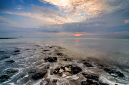Awesome sunrise with marvelous clouds. Slow shutter used to create foamy & hazy effect.の写真素材