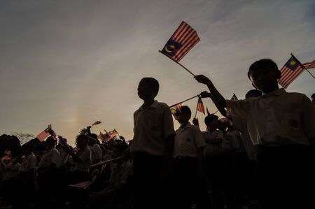 SK PAYA, PERLIS, MALAYSIA - JULY 17, 2012 : The pupils are waving the Malaysian flag as a symbolic celebration of the Independence Day.のeditorial素材