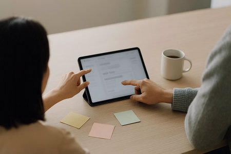 Businesswoman using digital tablet at table in office. Business woman working with tablet.の素材