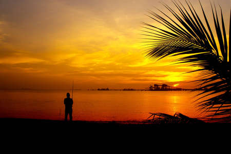 shore anglers silhouette at great sunsetの写真素材