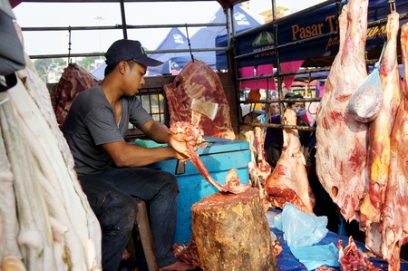 PAHANG, MALAYSIA-AUG 18: Unidentified traditional meat seller is split of beef at Pasar Ramadan...