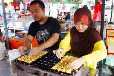 KOTA BHARU-JUNE 01: Two an unidentified street vendor prepares tokoyaki food on Wakaf Che Yeh on June 01, 2013 in Kota Bharu, Kelantan, Malaysia. Kelantan a haven for local food loversのeditorial素材