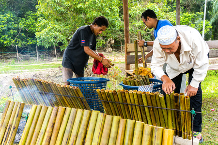 PAHANG, M'SIA-JULY 27: Unidentified Malaysian traditional food seller was cooking "lemang" at Kuantan town on July 27, 2014 in Pahang, Malaysia. Muslims around the world celebrate Aidilfitri tomorrowのeditorial素材