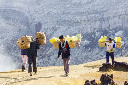KAWAH IJEN, INDONESIA - APRIL 7: Unidentified people miner carry baskets with sulfur from the sulfur mines in the crater of the active volcano of Kawah Ijen on April 7, 2014 in East Java, Indonesiaのeditorial素材