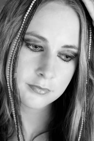 Beautiful female model with beads and heavy make-upの写真素材