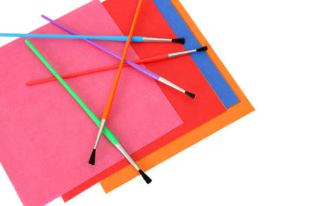 Multi coloured sheets of paper and paint brushesの写真素材