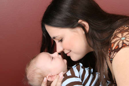 Brunette mother holding her newborn baby boyの写真素材