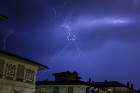 Lightning at night during a storm in the sky of Lausanne, Switzerlandの写真素材
